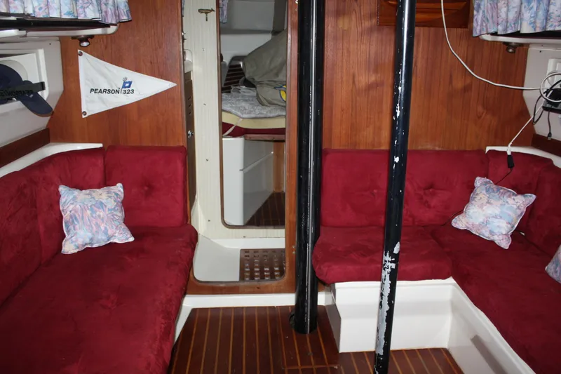 Slide: The Image of Interior of a 1979 Pearson 323 sailboat with red seating and wood paneling. - 23