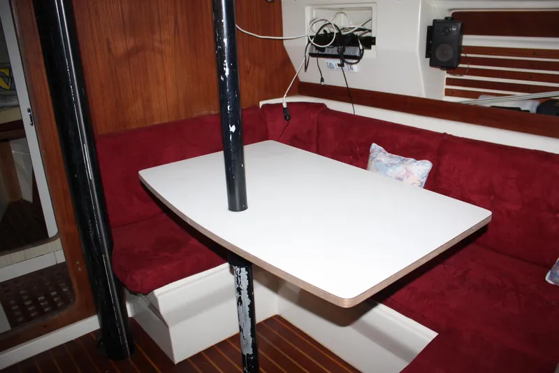 Slide: The Image of 1979 Pearson 323 sailboat interior with red seating and white table. - 25