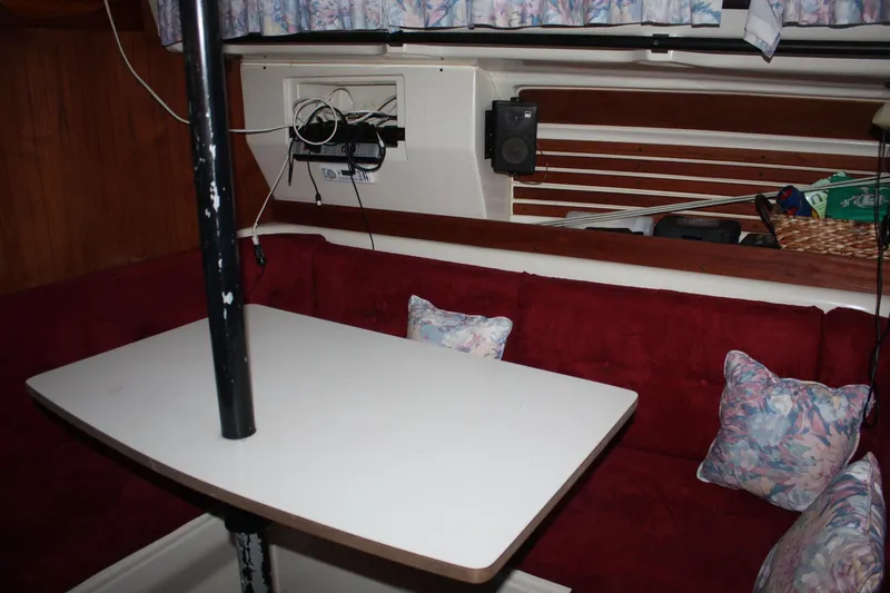 Slide: The Image of Interior of a 1979 Pearson 323 sailboat with red seating and a white table. - 26