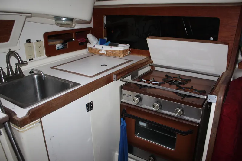 Slide: The Image of 1979 Pearson 323 yacht kitchen with sink, stove, and storage. - 29