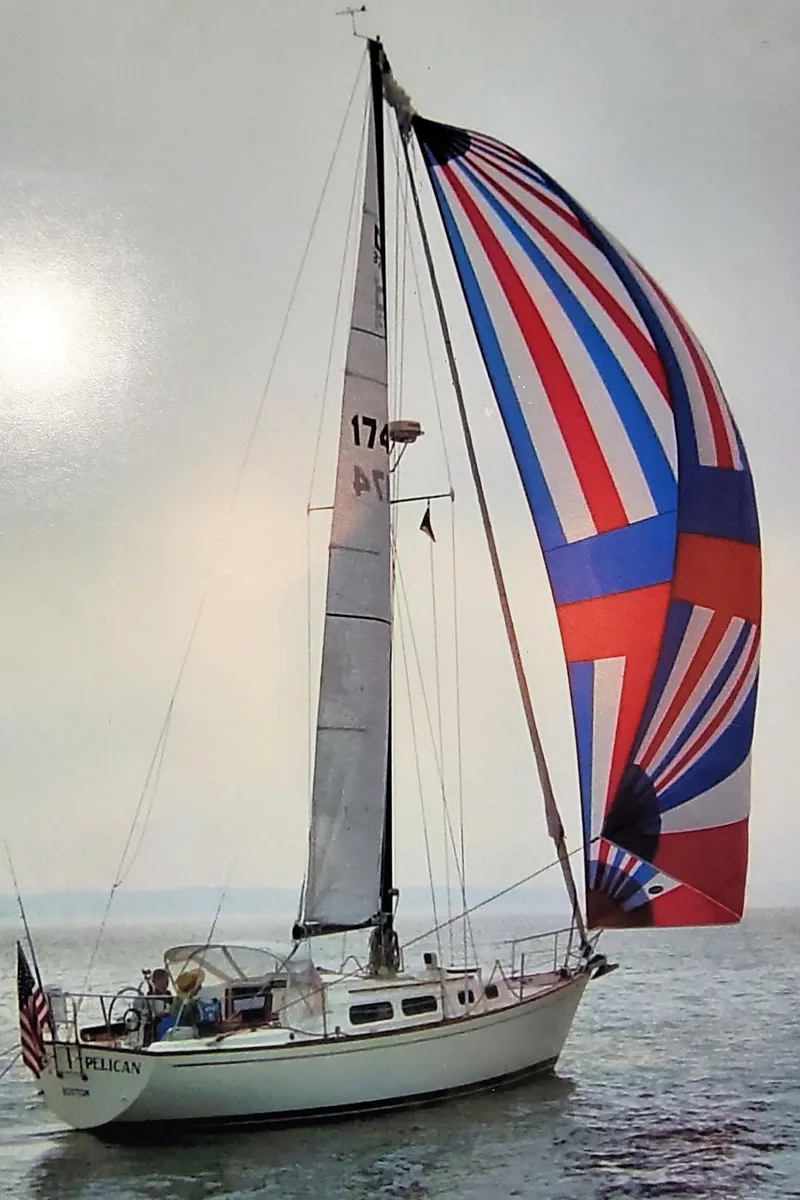 Slide: The Image of 1979 Pearson 323 sailboat with colorful spinnaker on open water. - 3