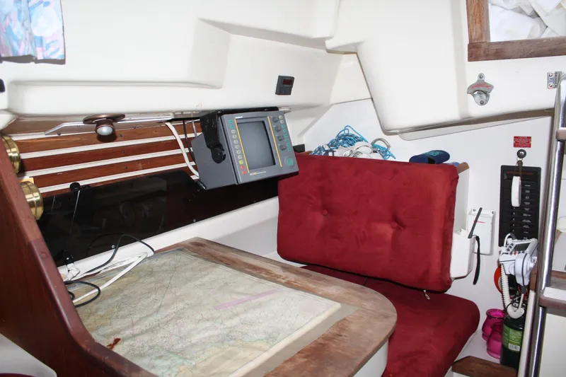 Slide: The Image of Navigation station inside 1979 Pearson 323 sailboat with chart, red seat, and equipment. - 31