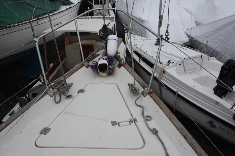 Slide: The Image of 1979 Pearson 323 sailboat deck with rigging and equipment, docked alongside other boats. - 9