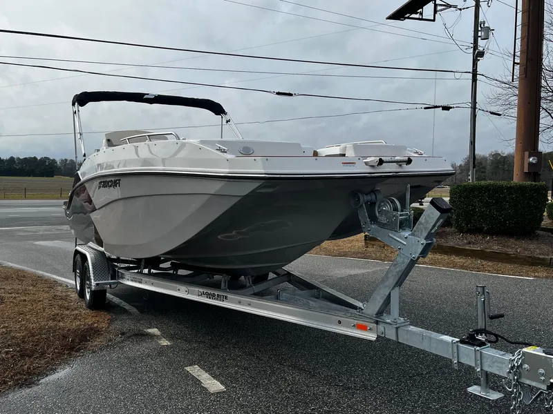 Slide: The Image of 2024 Starcraft SVX 231 boat on a trailer, parked on a roadside. - 2