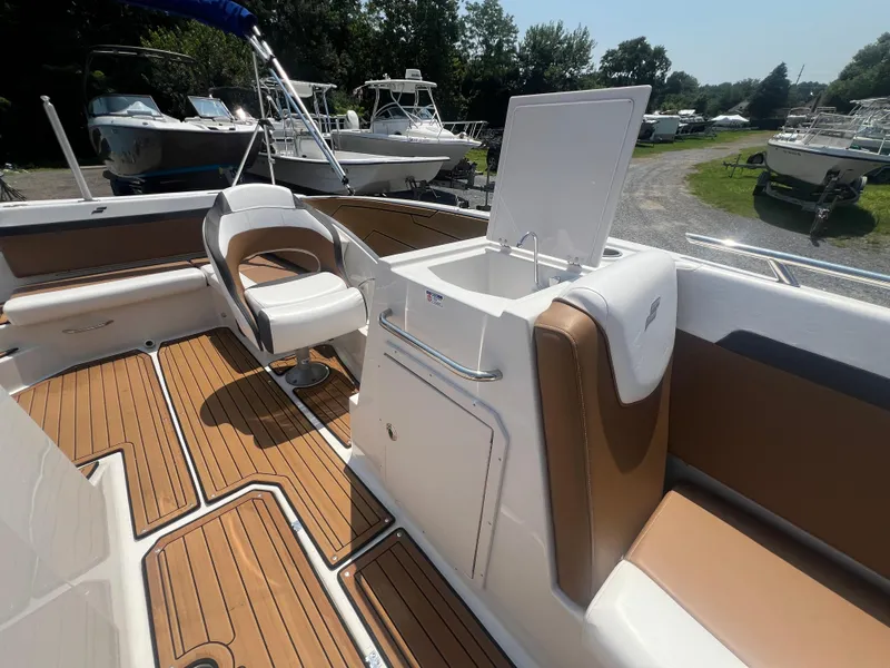Slide: The Image of 2023 Starcraft SVX 231 OB DH boat interior with seating and open storage compartment. - 11