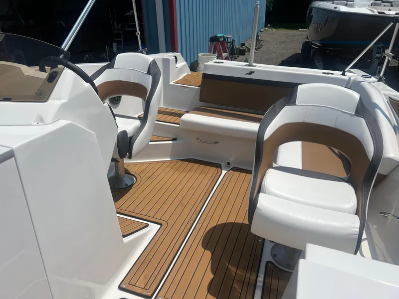 Slide: The Image of 2023 Starcraft SVX 231 OB DH boat interior with white seating and wood-style flooring. - 13