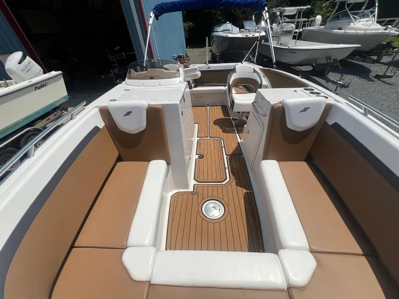 Slide: The Image of 2023 Starcraft SVX 231 OB DH boat interior with tan and white seating, wood flooring. - 15