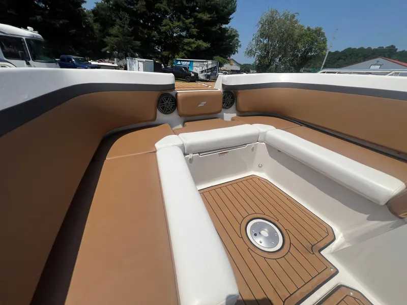 Slide: The Image of 2023 Starcraft SVX 231 OB DH boat interior with tan and white seating, wood-style flooring. - 22