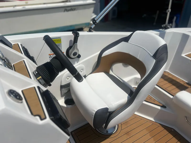 Slide: The Image of Captain's seat on 2023 Starcraft SVX 231 OB DH boat, featuring modern controls and design. - 23
