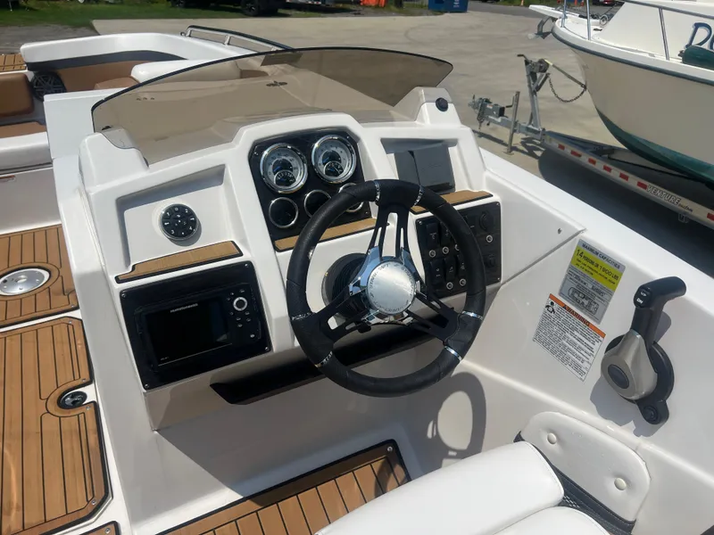 Slide: The Image of 2023 Starcraft SVX 231 OB DH boat dashboard with steering wheel and controls. - 24
