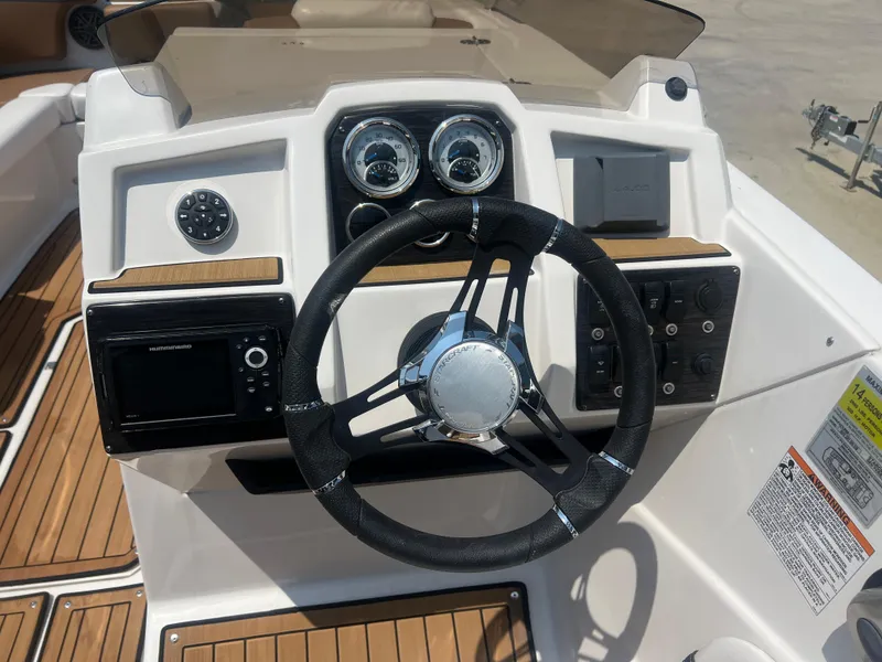 Slide: The Image of 2023 Starcraft SVX 231 OB DH boat dashboard with steering wheel and control panel. - 25