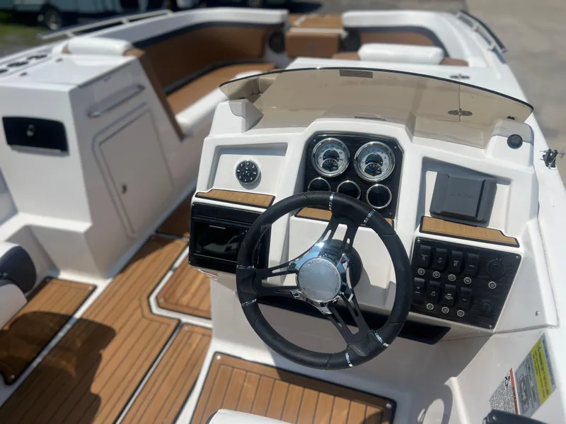 Slide: The Image of 2023 Starcraft SVX 231 OB DH boat dashboard with steering wheel and controls. - 26