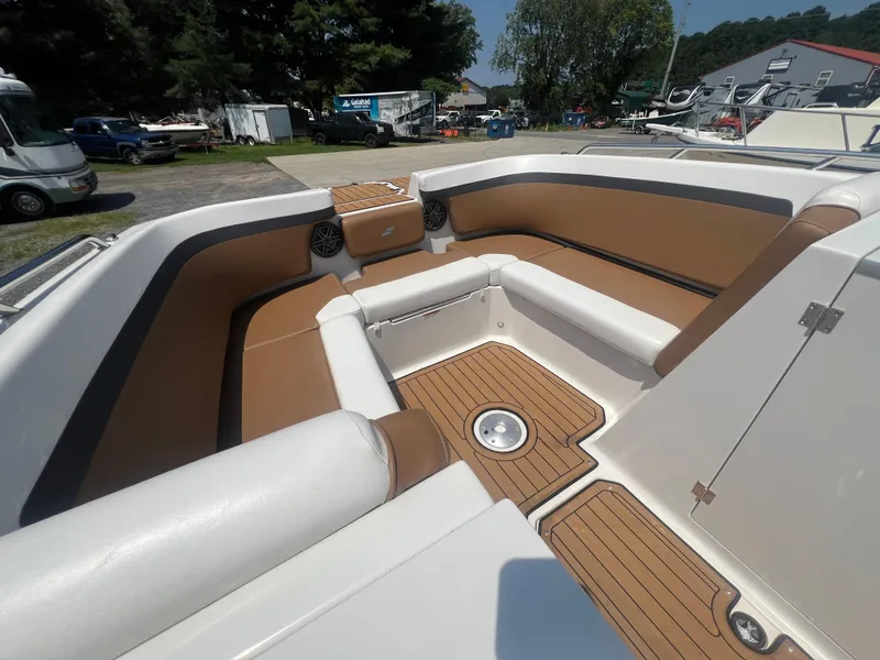 Slide: The Image of 2023 Starcraft SVX 231 OB DH boat interior with tan and white seating, wood-style flooring. - 30