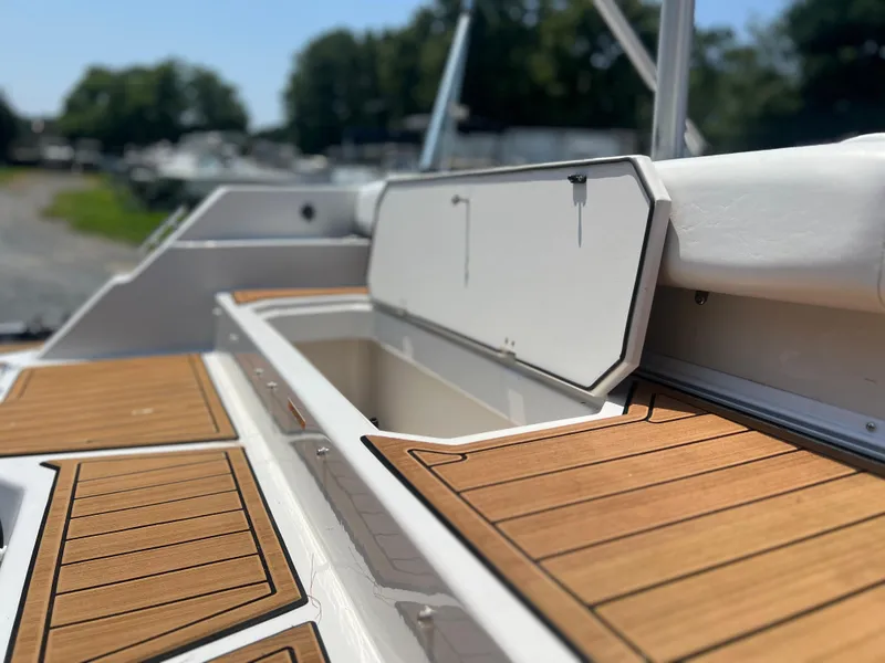 Slide: The Image of 2023 Starcraft SVX 231 OB DH boat with open storage compartment and teak-style flooring. - 36