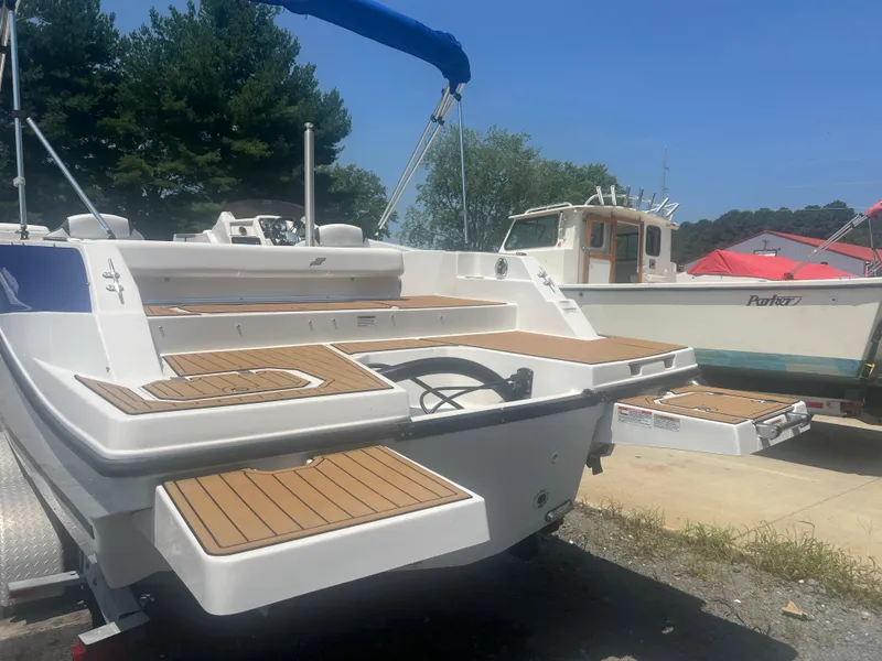 Slide: The Image of 2023 Starcraft SVX 231 OB DH boat with wooden deck, parked outdoors. - 37