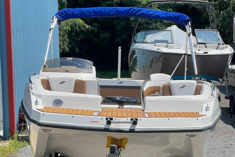 Slide: The Image of 2023 Starcraft SVX 231 OB DH boat with blue canopy, docked outdoors. - 40