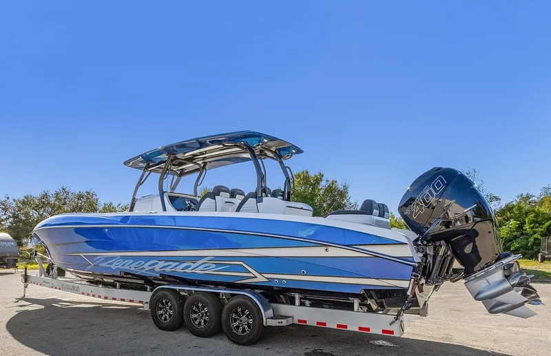 Slide: The Image of 2023 Renegade 38 Open boat on trailer, blue and white design, powerful outboard engines. - 12