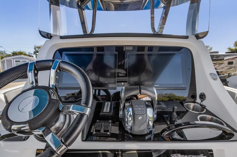 Slide: The Image of 2023 Renegade 38 Open boat dashboard with steering wheel and dual screens. - 18