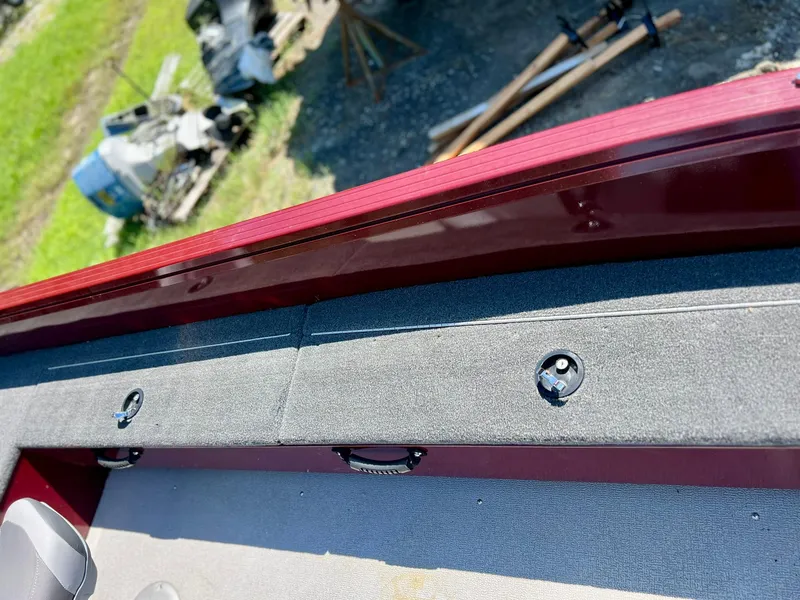 Slide: The Image of 2023 Starcraft Storm 166 SC boat interior with red trim and gray carpet. - 16