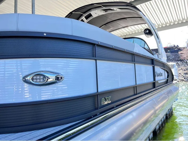 Slide: The Image of 2023 Manitou LX 25 SRW pontoon boat with sleek design and split rear windshield. - 10