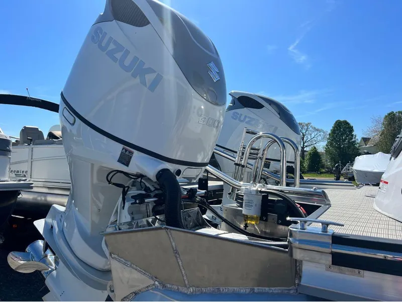 Slide: The Image of 2023 Manitou LX 25 SRW with Suzuki outboard engines in a sunny outdoor setting. - 12
