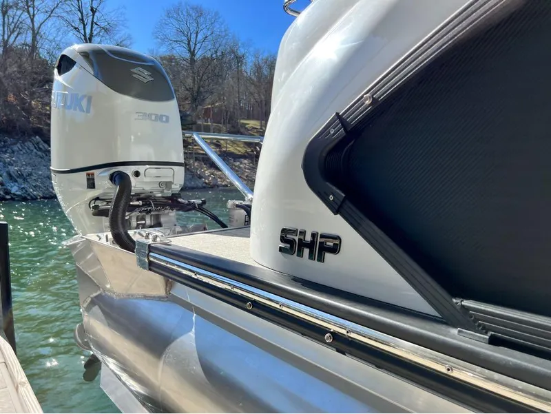 Slide: The Image of 2023 Manitou LX 25 SRW pontoon boat with Suzuki 300 engine on a sunny day. - 16