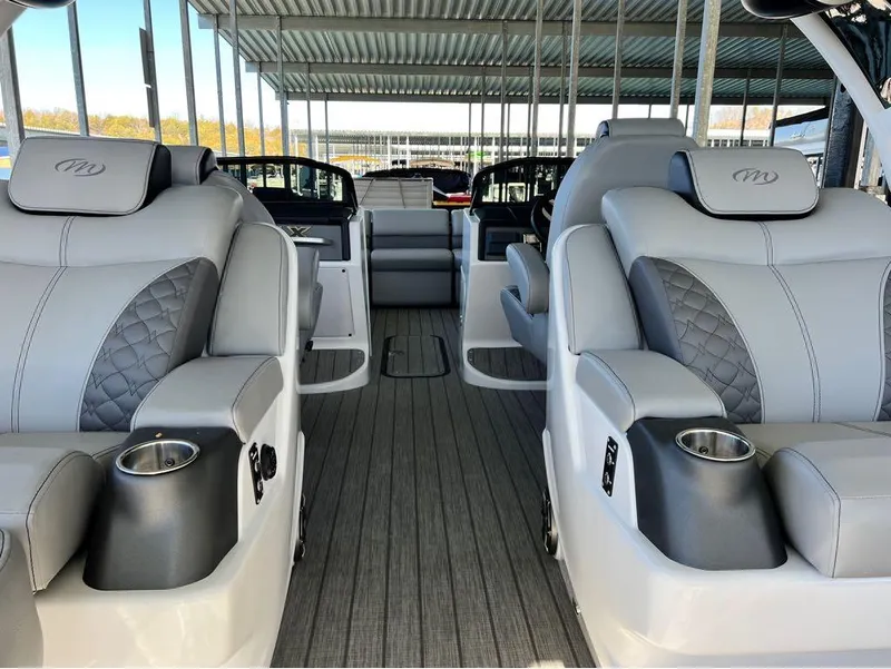 Slide: The Image of Luxurious interior of 2023 Manitou LX 25 SRW pontoon boat with plush seating and cup holders. - 17