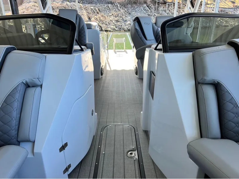 Slide: The Image of 2023 Manitou LX 25 SRW boat interior with split rear windshield and luxurious seating. - 28