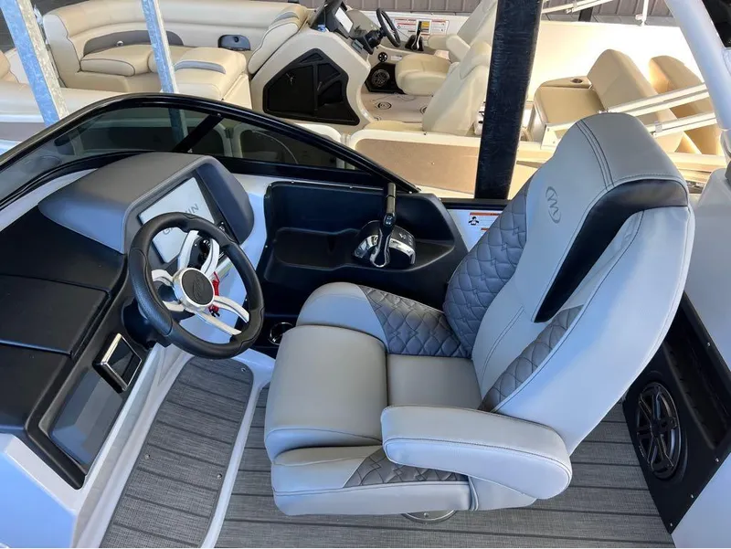 Slide: The Image of 2023 Manitou LX 25 SRW boat interior with luxury seating and steering wheel. - 3