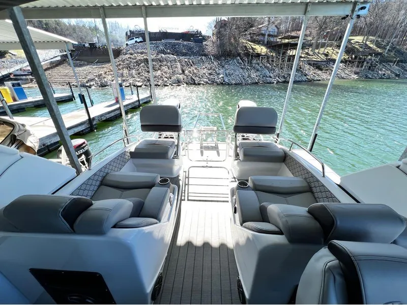 Slide: The Image of 2023 Manitou LX 25 SRW pontoon boat interior with plush seating and lake view. - 38