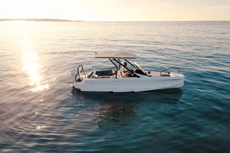 Slide: The Image of 2022 Axopar 22 T-Top x Jobe Revolve boat interior with blue cover and sleek design. - 12