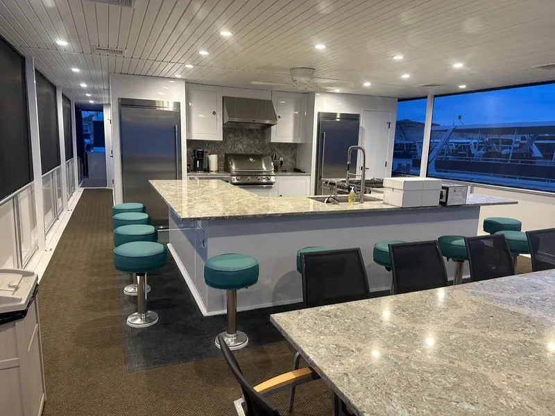 Slide: The Image of Modern kitchen on Adonia Meticulous Share #7 houseboat, featuring granite countertops and teal bar stools, 2023. - 3