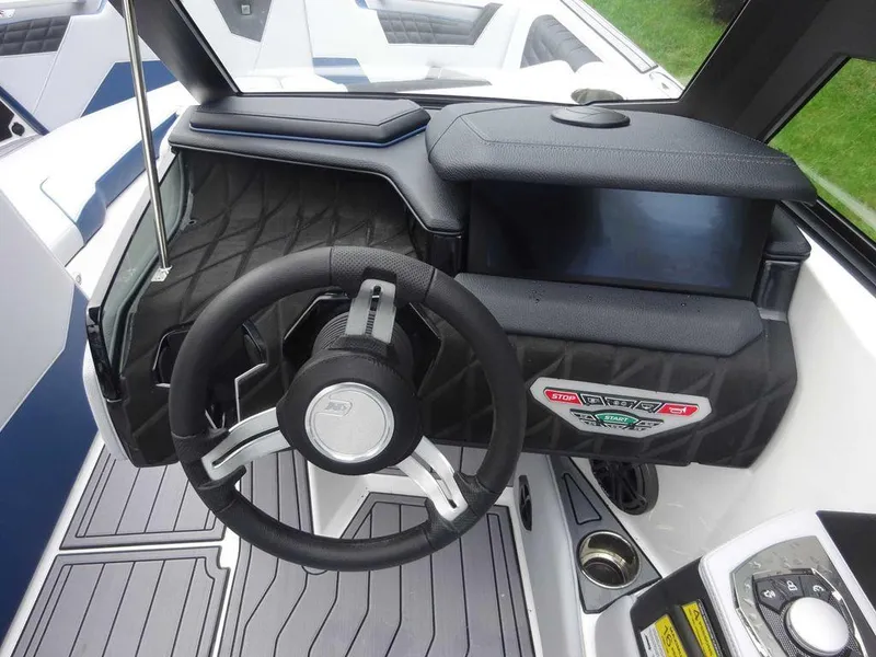 Slide: The Image of 2023 Nautique S23 boat dashboard with steering wheel and touchscreen display. - 11