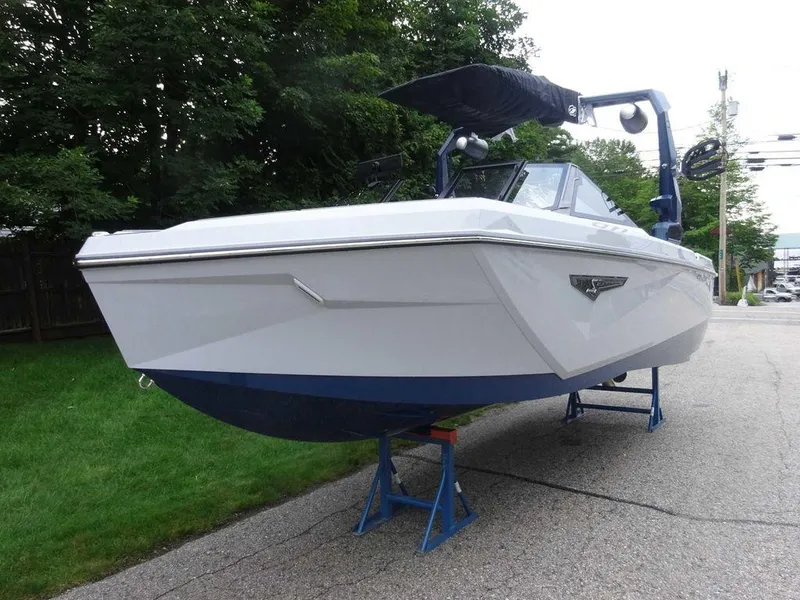 Slide: The Image of 2023 Nautique S23 boat on stands, white hull with blue accents. - 15