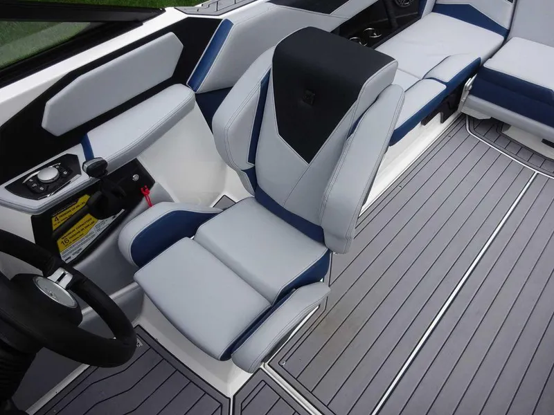 Slide: The Image of 2023 Nautique S23 boat interior with captain's chair and seating area. - 6