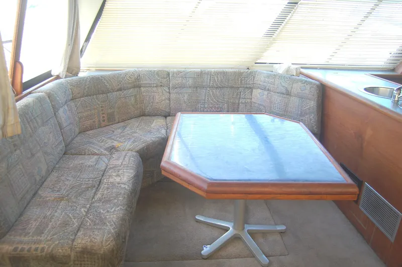 Slide: The Image of Interior of 1992 Bayliner 4588 Pilothouse MY with cushioned seating and wooden table. - 13
