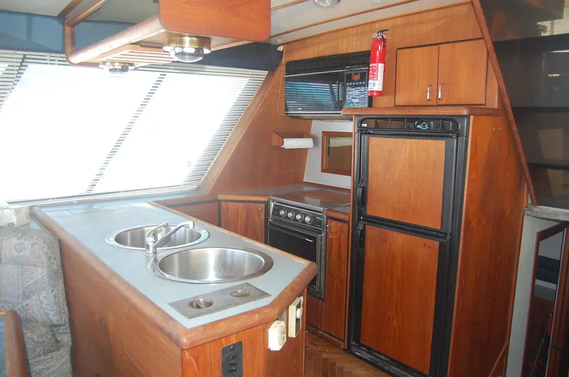 Slide: The Image of 1992 Bayliner 4588 Pilothouse MY kitchen with wood cabinetry and dual sinks. - 2