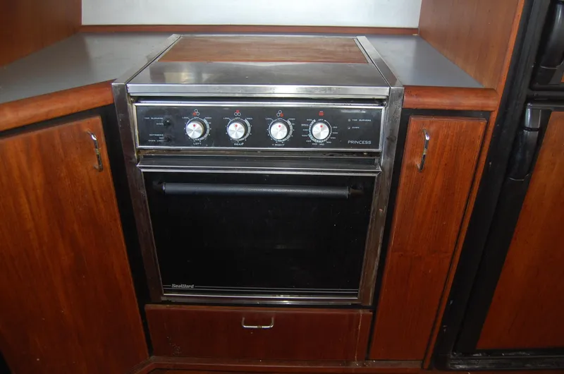 Slide: The Image of 1992 Bayliner 4588 Pilothouse MY kitchen oven with wooden cabinetry. - 25