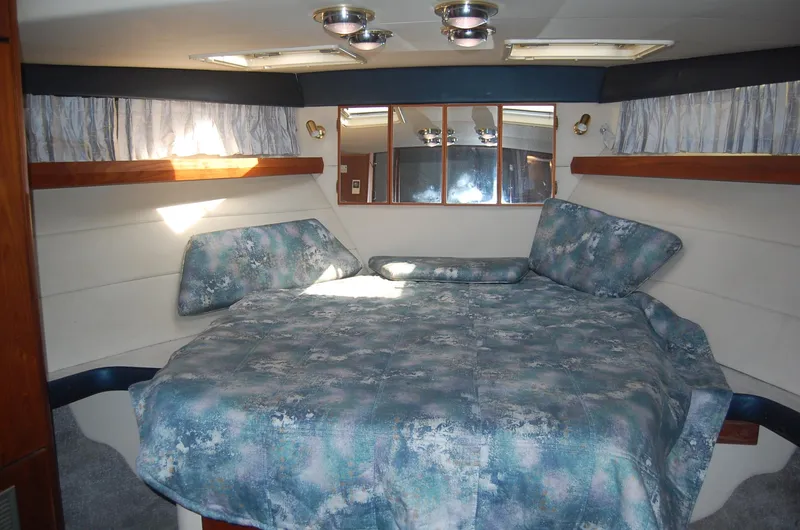 Slide: The Image of Cozy bedroom in 1992 Bayliner 4588 Pilothouse MY with blue bedding and mirrored wall. - 3