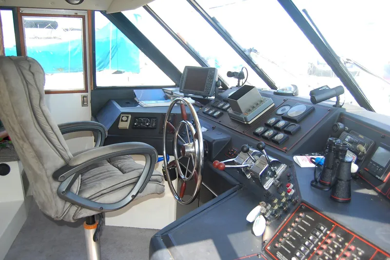 Slide: The Image of 1992 Bayliner 4588 Pilothouse MY helm with steering wheel, controls, and navigation equipment. - 4