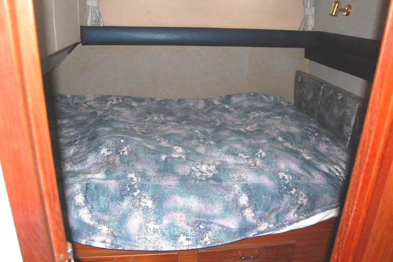 Slide: The Image of 1992 Bayliner 4588 Pilothouse MY cabin with a cozy bed and floral bedding. - 43