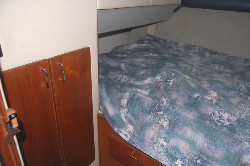 Slide: The Image of 1992 Bayliner 4588 Pilothouse MY cabin with bed and wooden storage cabinets. - 44
