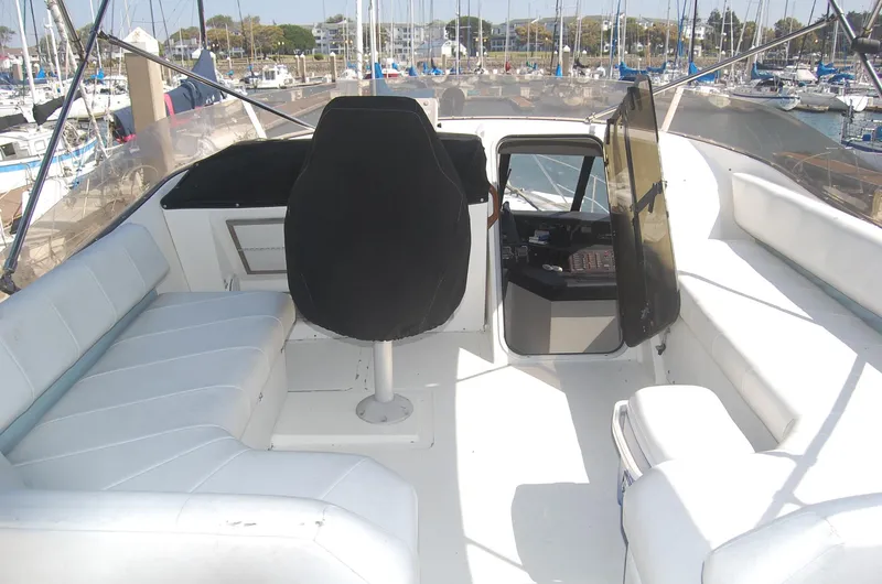 Slide: The Image of 1992 Bayliner 4588 Pilothouse yacht interior with seating and helm, docked at marina. - 5