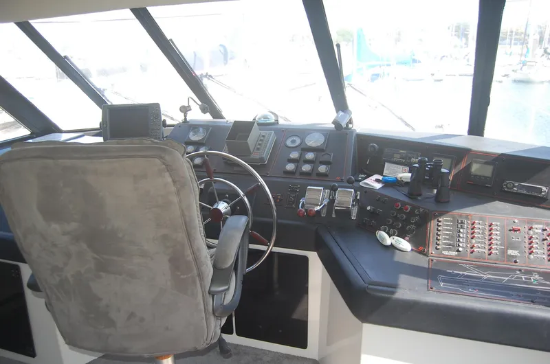 Slide: The Image of 1992 Bayliner 4588 Pilothouse MY helm with steering wheel, controls, and navigation instruments. - 50