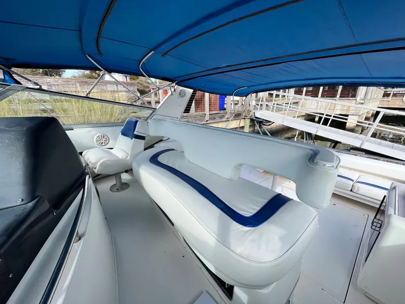 Slide: The Image of 1993 Sea Ray 440 Sundancer boat interior with blue and white seating. - 12