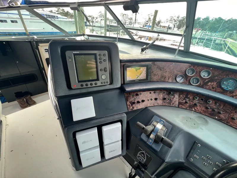 Slide: The Image of 1993 Sea Ray 440 Sundancer helm with navigation equipment and controls. - 13