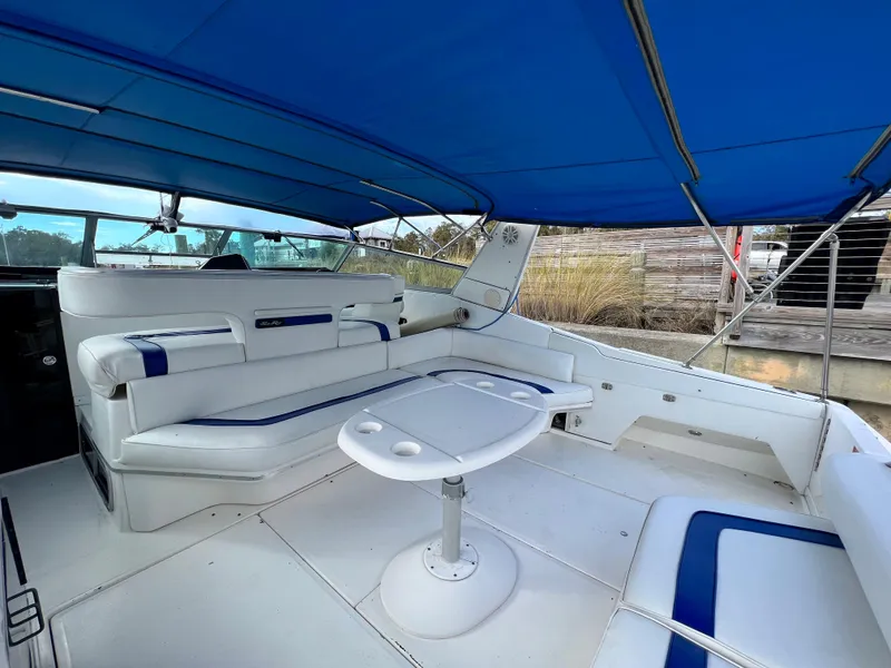 Slide: The Image of 1993 Sea Ray 440 Sundancer boat interior with blue canopy and white seating. - 16