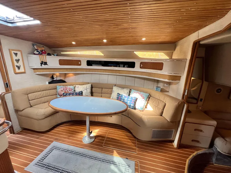 Slide: The Image of Interior of 1993 Sea Ray 440 Sundancer with cozy seating and wooden accents. - 19