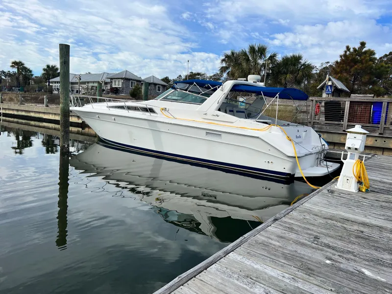 Slide: The Image of 1993 Sea Ray 440 Sundancer docked at a marina on a sunny day. - 2