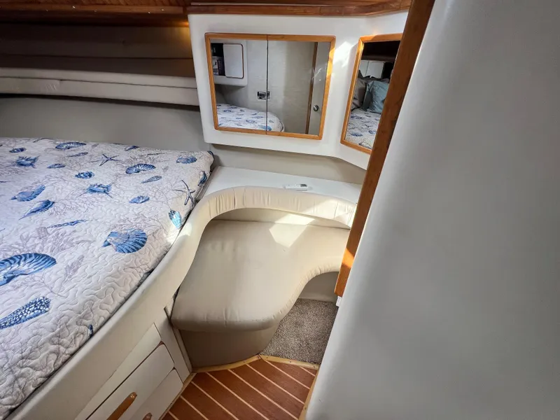 Slide: The Image of 1993 Sea Ray 440 Sundancer cabin with bed, mirrors, and seating area. - 24